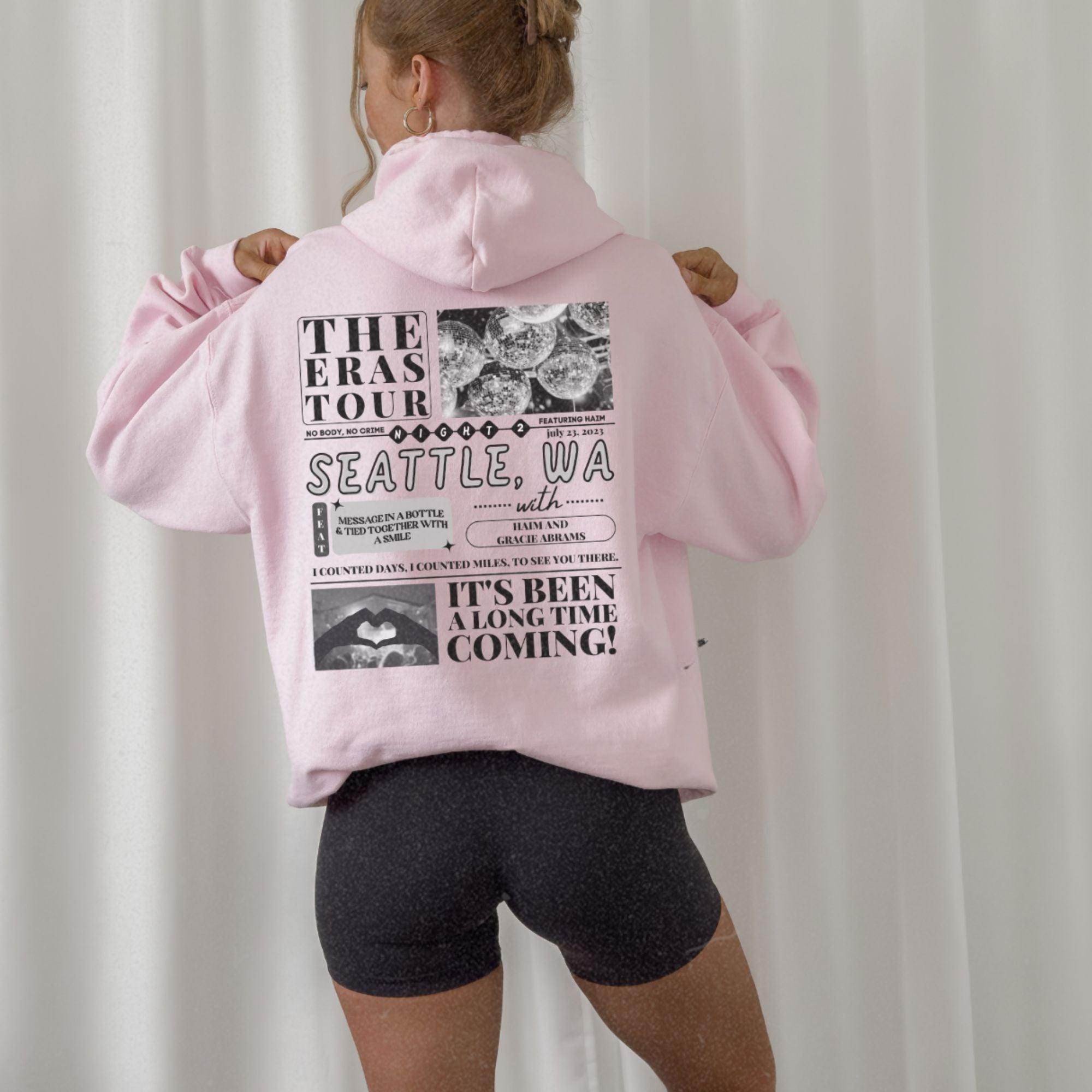 a woman wearing a pink hoodie and black shorts