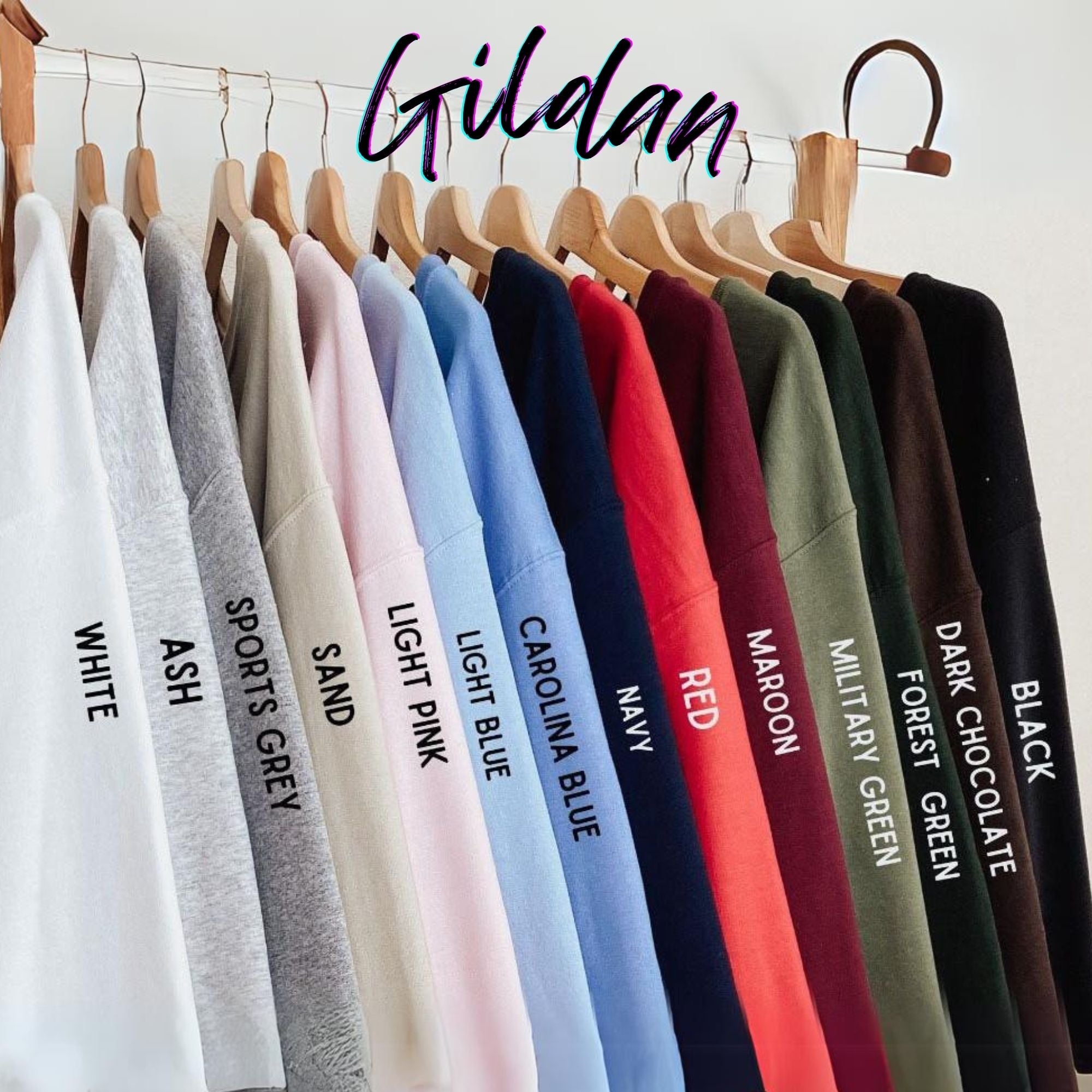 A row of colorful t-shirts hanging on a clothing rack, with each shirt displaying a different color and text label.