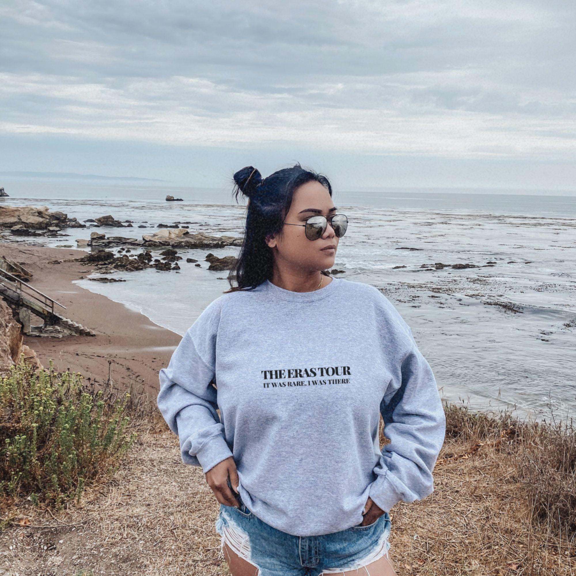 a woman standing on a beach next to the ocean