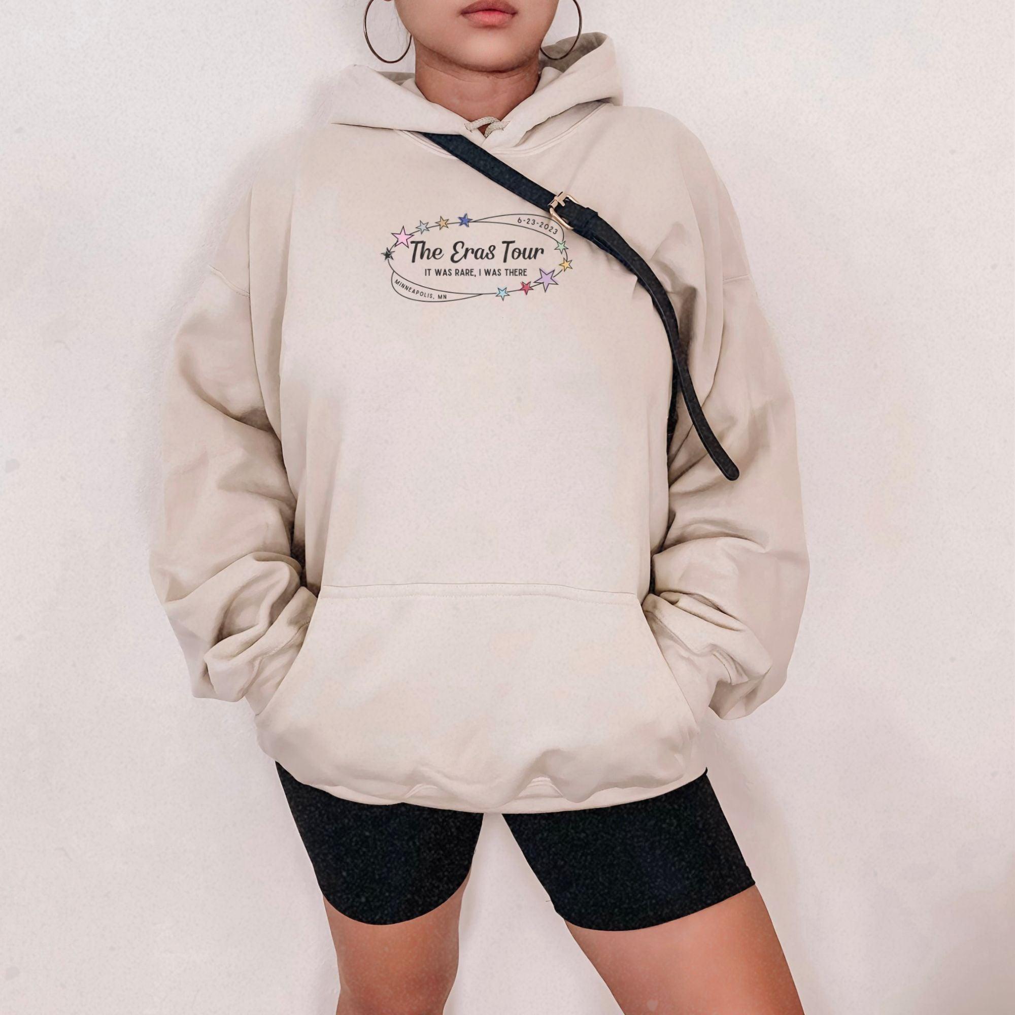 a woman wearing a white sweatshirt and black shorts