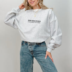 a woman wearing a grey sweatshirt and jeans