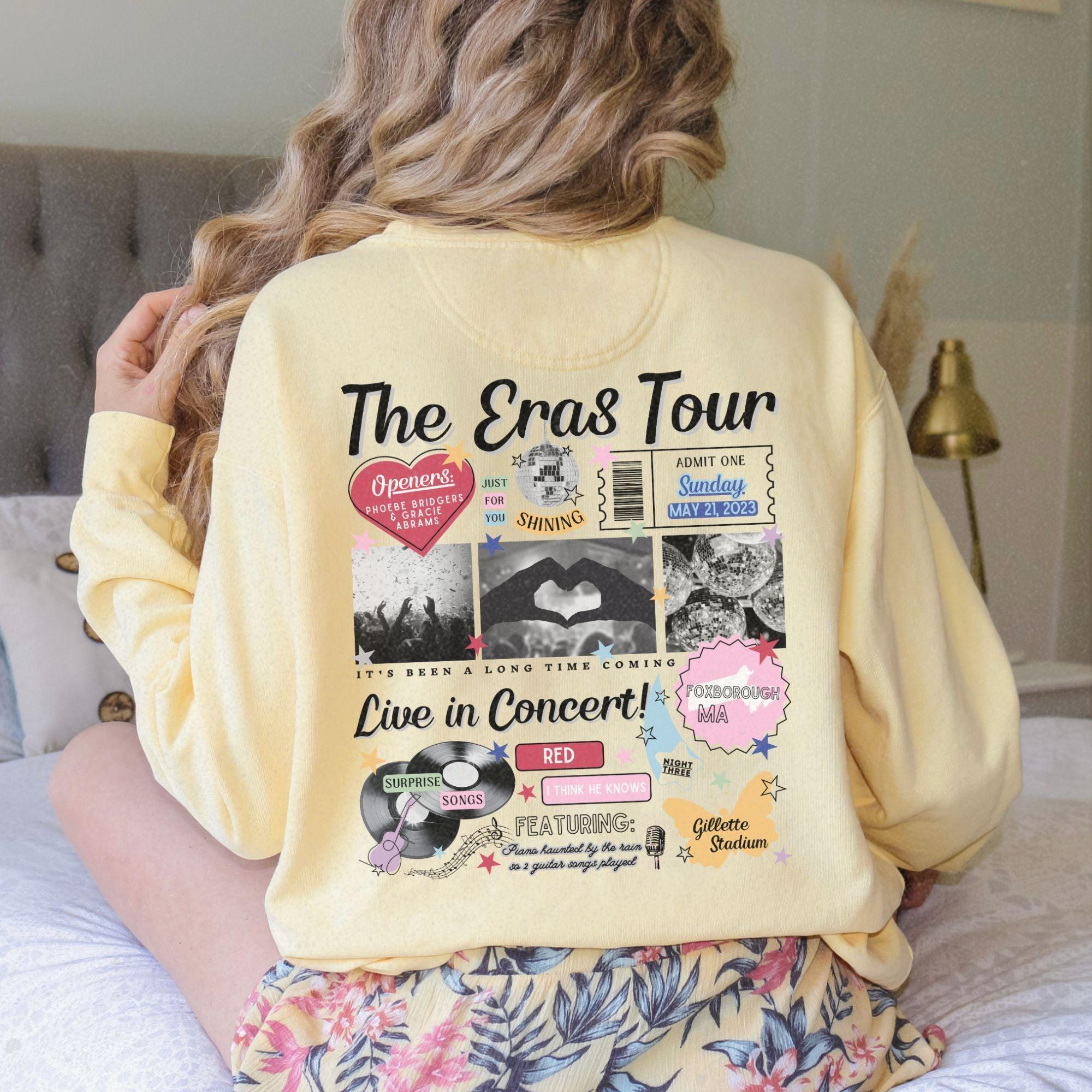 a woman sitting on a bed wearing a yellow sweatshirt