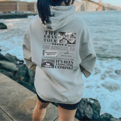 a woman walking along a pier next to the ocean