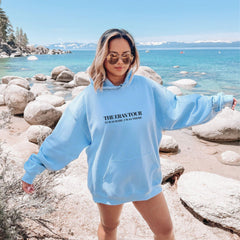 a woman in a blue hoodie standing on a beach