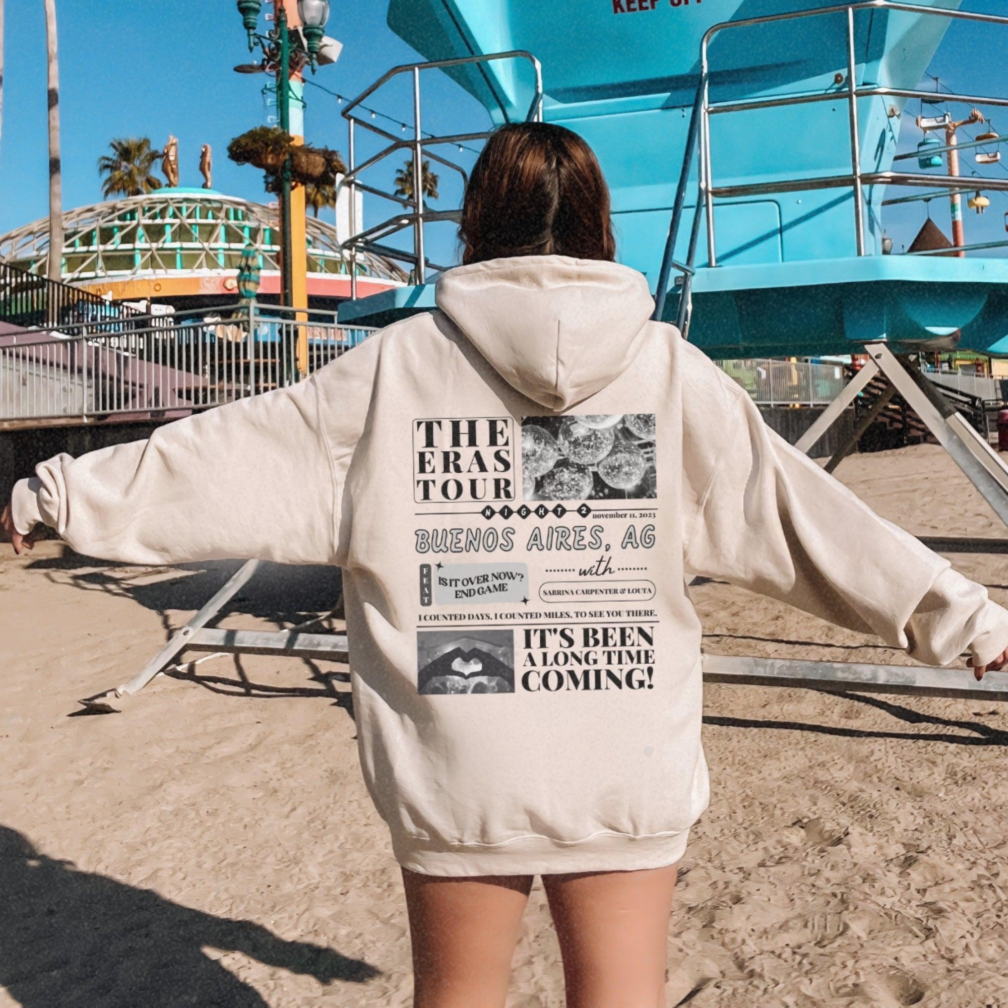 a woman in a white hoodie standing on a beach