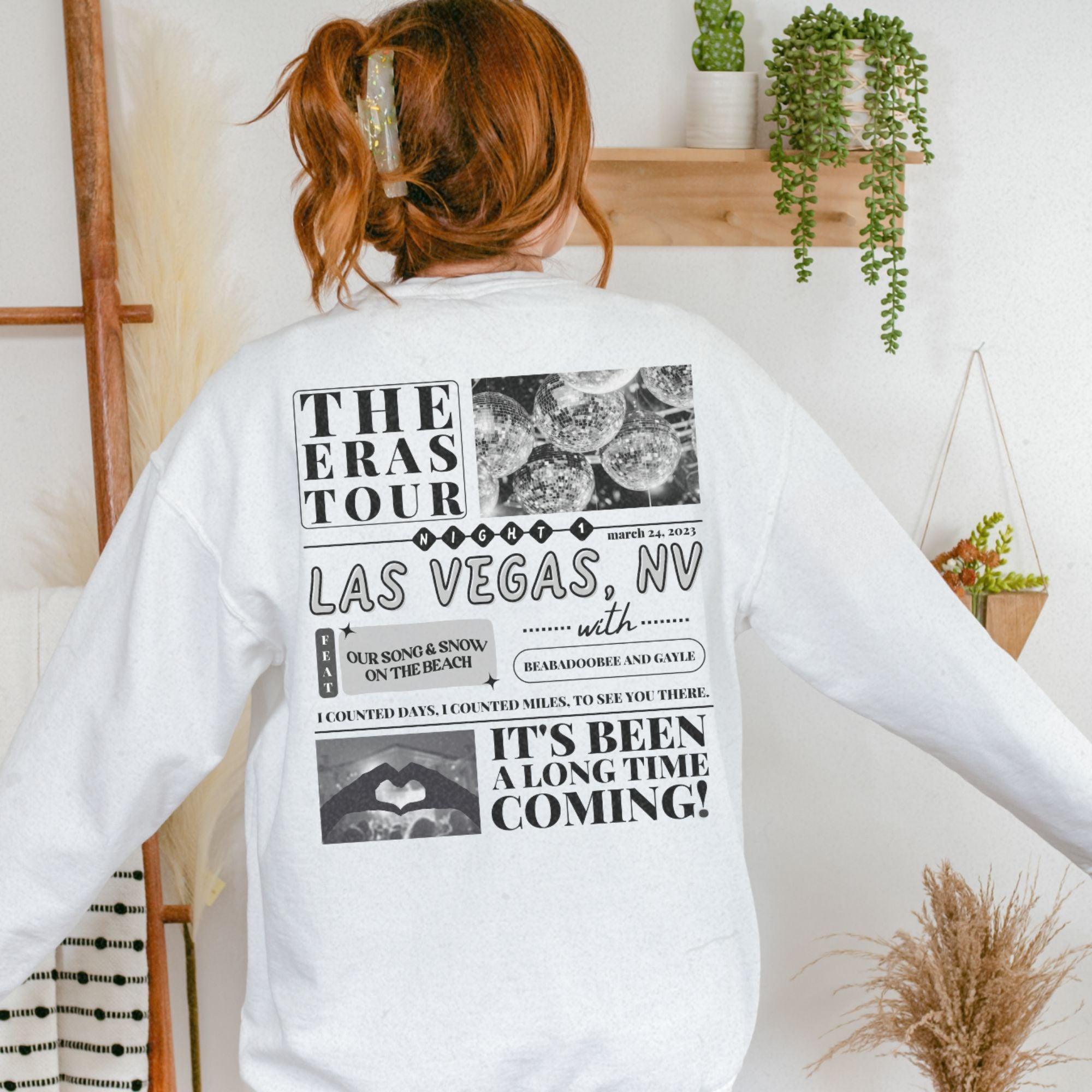 a woman standing in front of a wall wearing a white sweatshirt