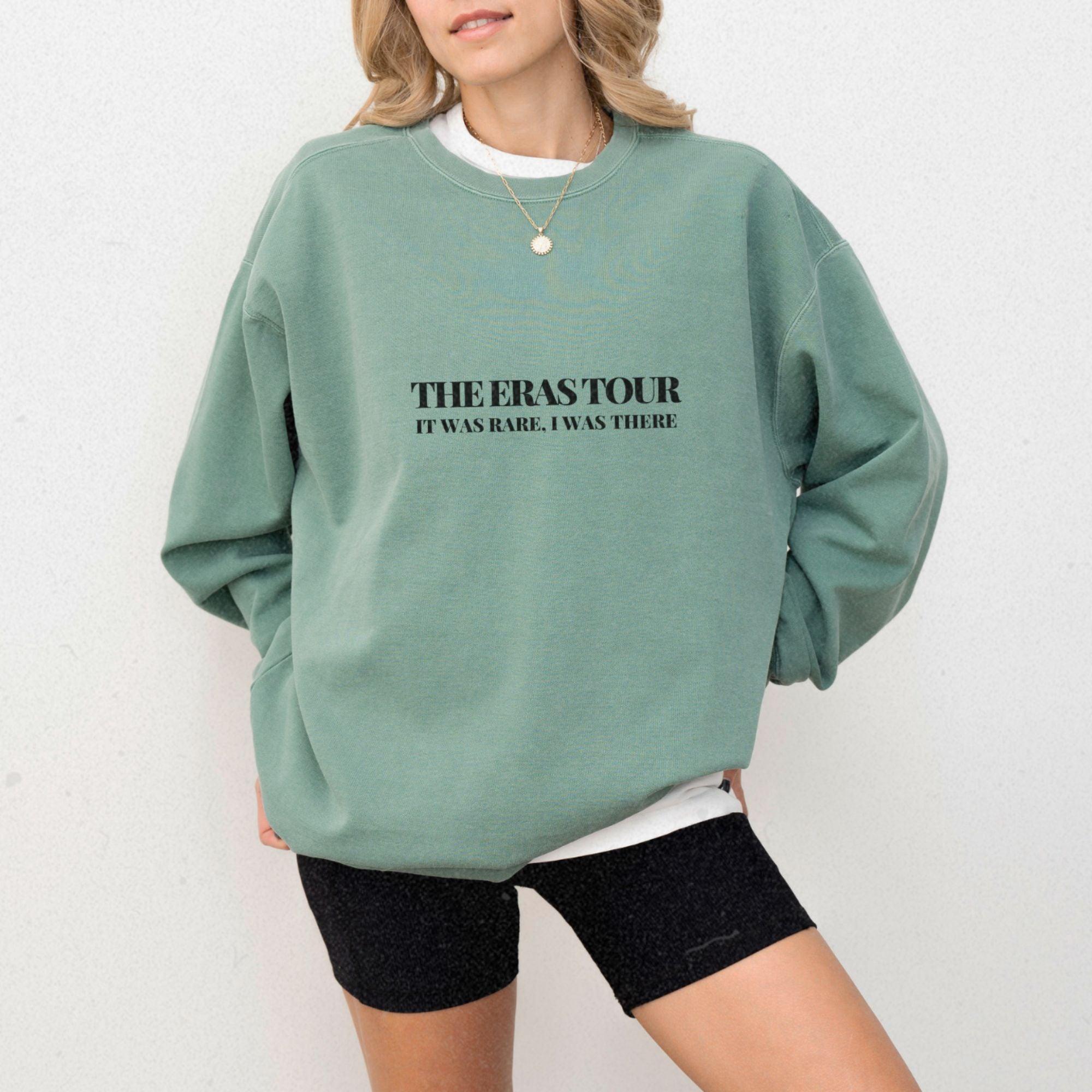 a woman wearing a green sweatshirt with the words the perks tour on it