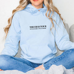 a woman sitting on a couch wearing a blue hoodie