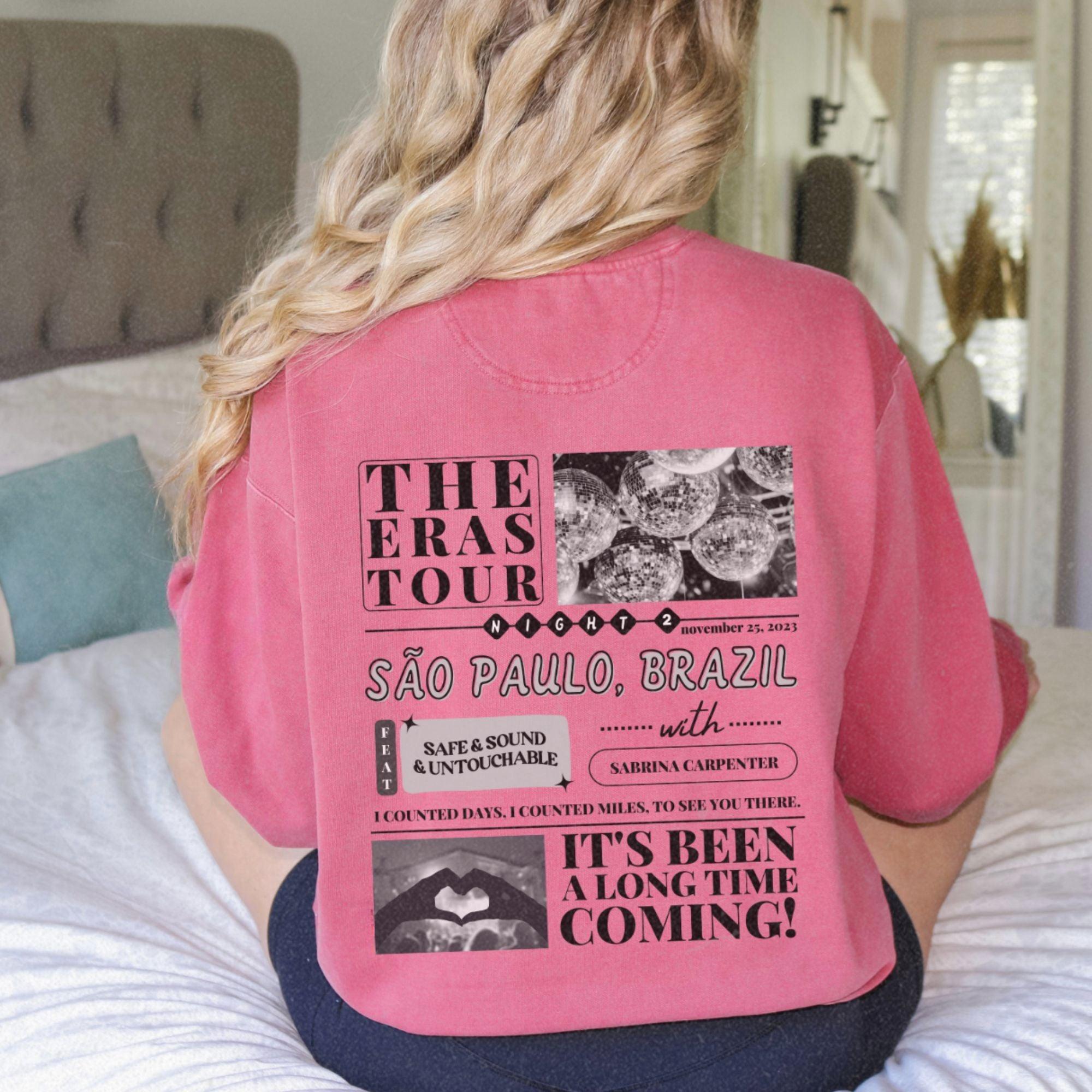 a woman sitting on a bed wearing a pink shirt