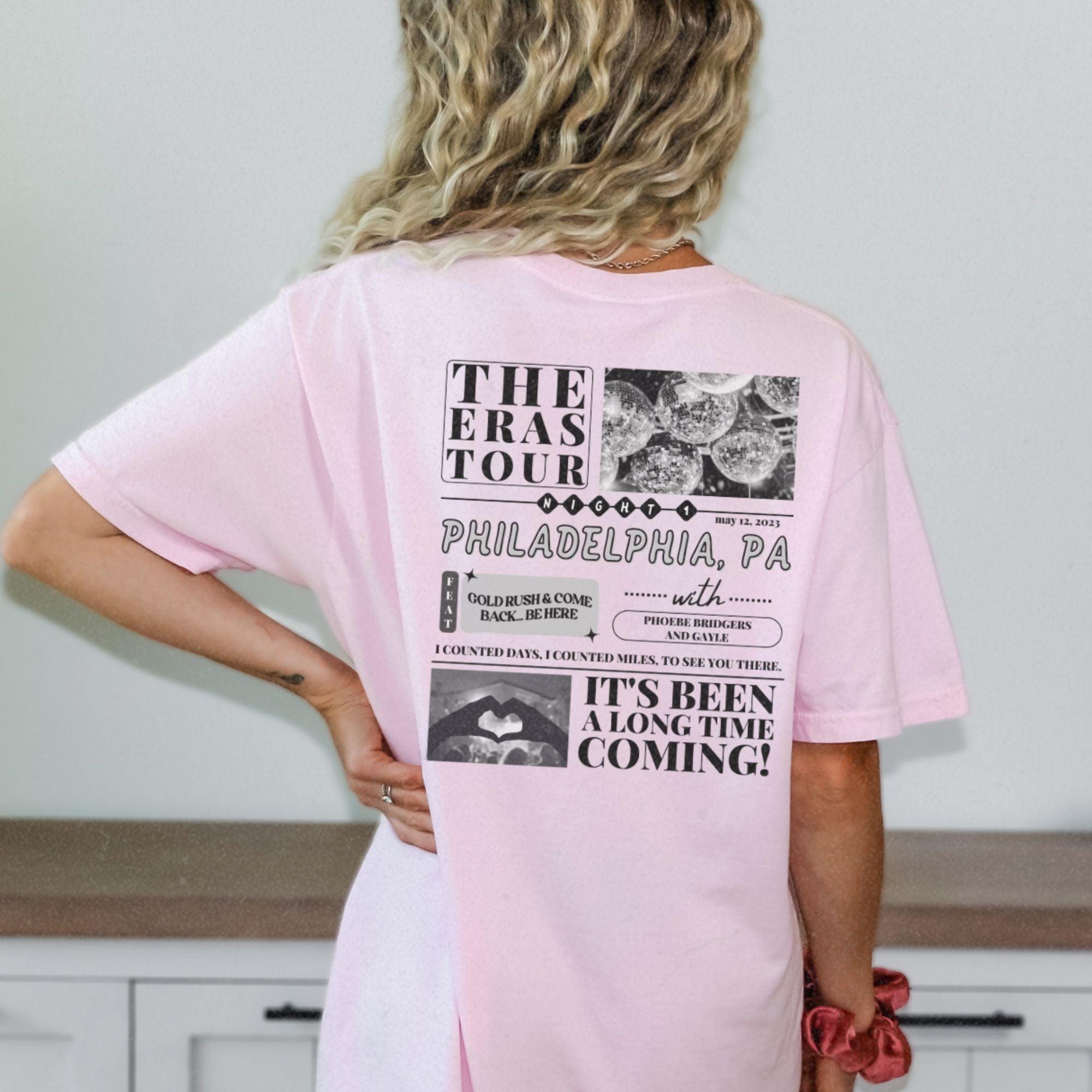 a woman wearing a pink tshirt with the words the eras tour philadelphia pa