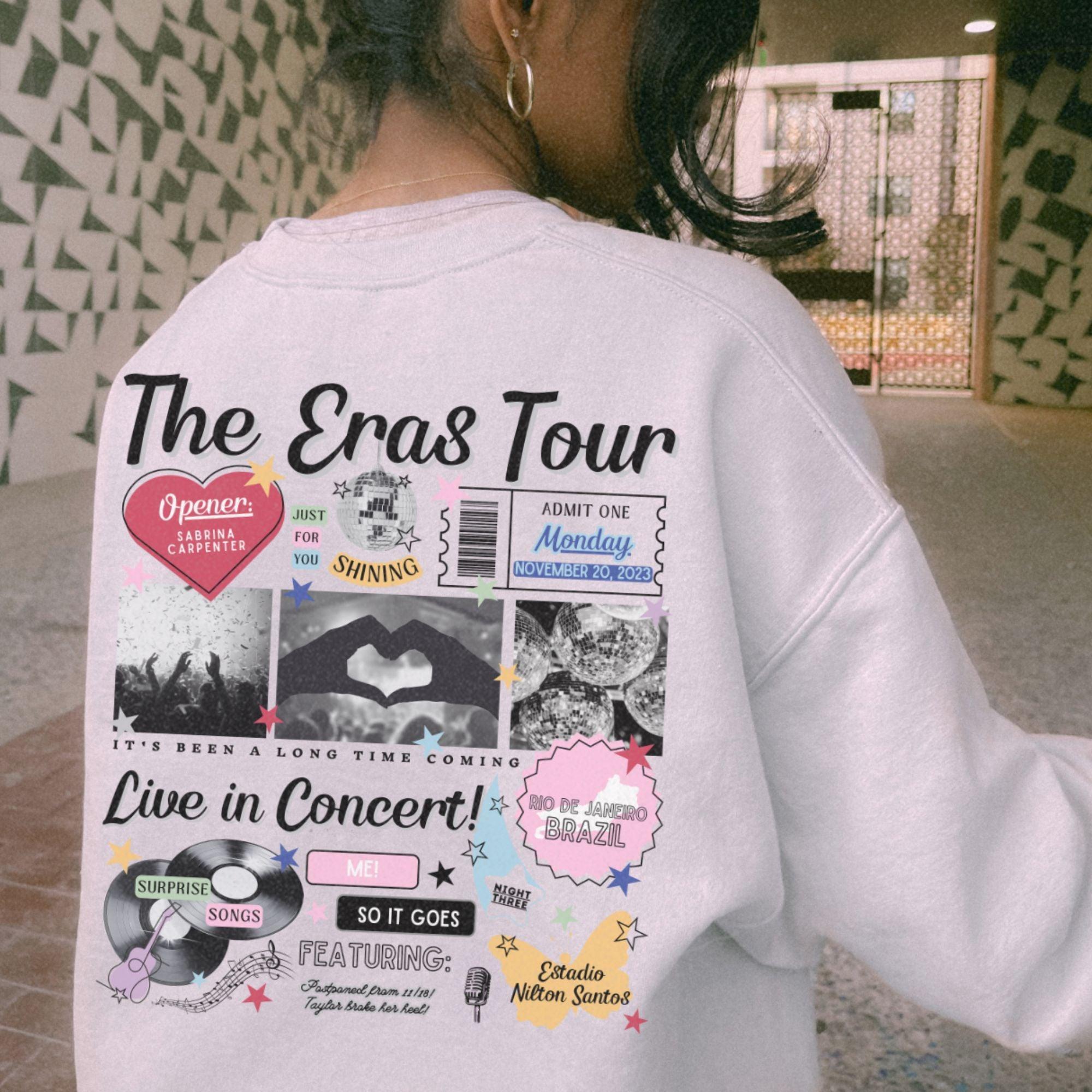 a woman wearing a white sweatshirt with the words the eras tour on it