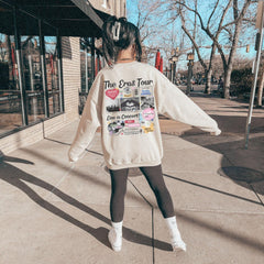 a woman walking down a sidewalk wearing a white sweater