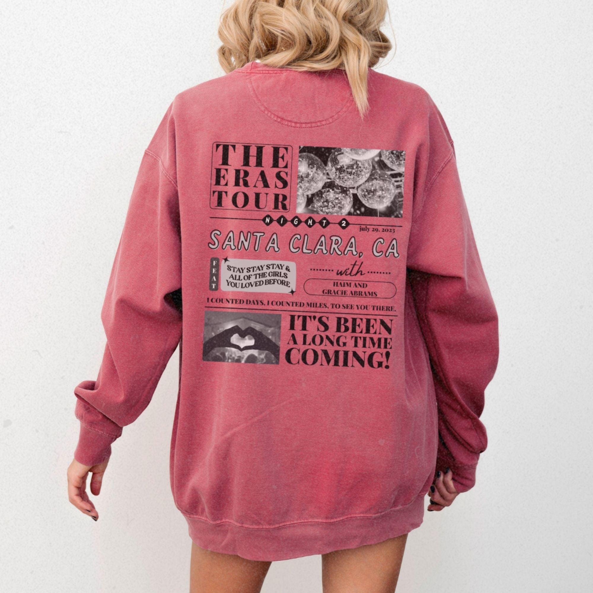 a woman wearing a pink sweatshirt with a back print