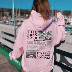 a woman in a pink hoodie looking at boats