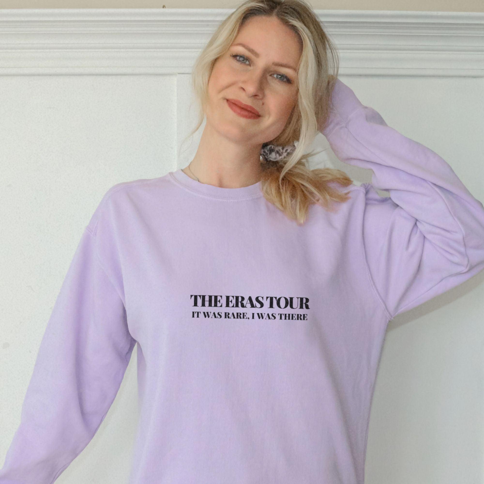 a woman wearing a purple sweatshirt with the words the east tour on it