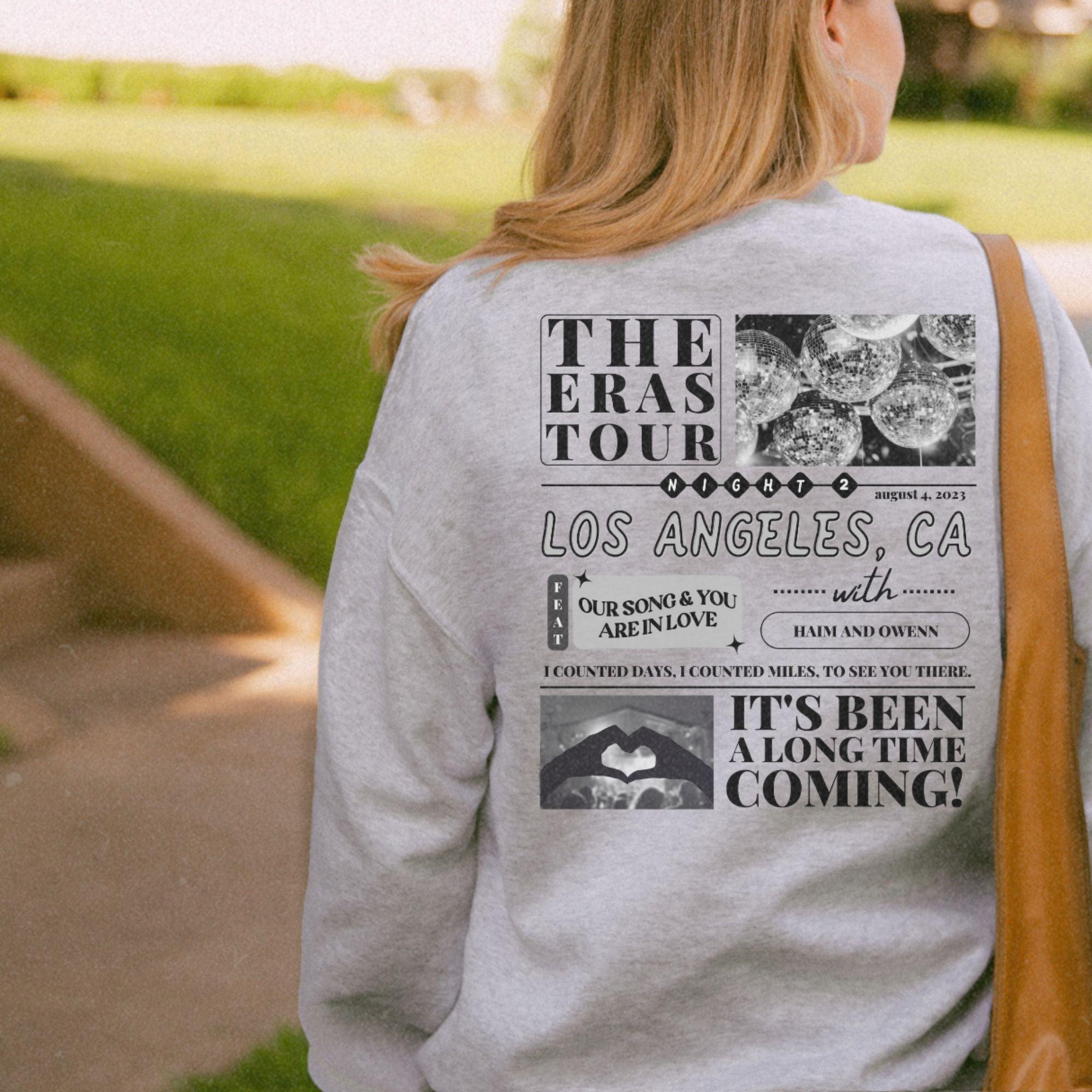 a woman in a gray sweatshirt is holding a brown bag