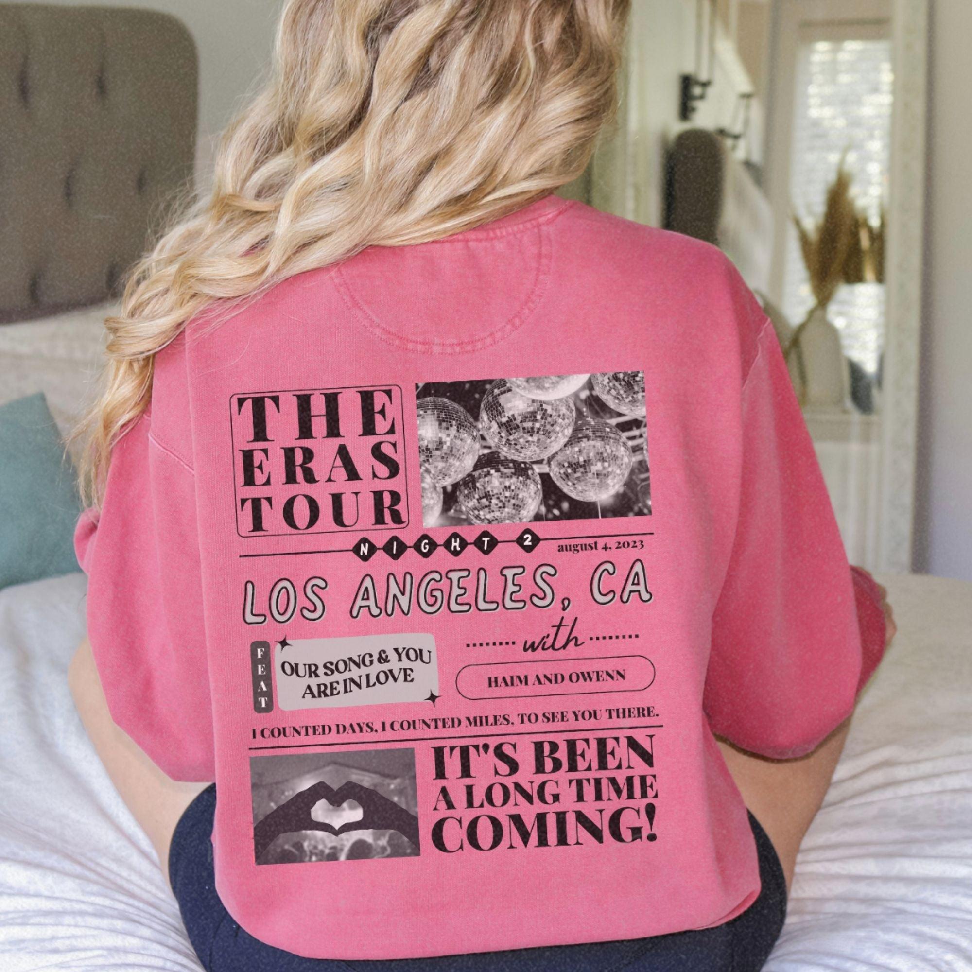 a woman sitting on a bed wearing a pink shirt