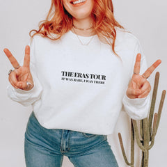 a woman with red hair wearing a white sweatshirt and jeans